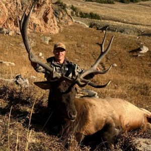 Hunter posing with his 6x6 bull elk harvested in wyoming
