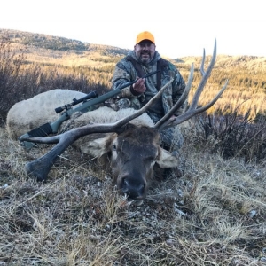 Hunter posing with his bull elk in Wyoming